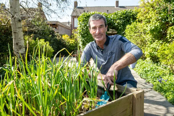 Persoon die buiten in een groene tuin aan het werken is.
